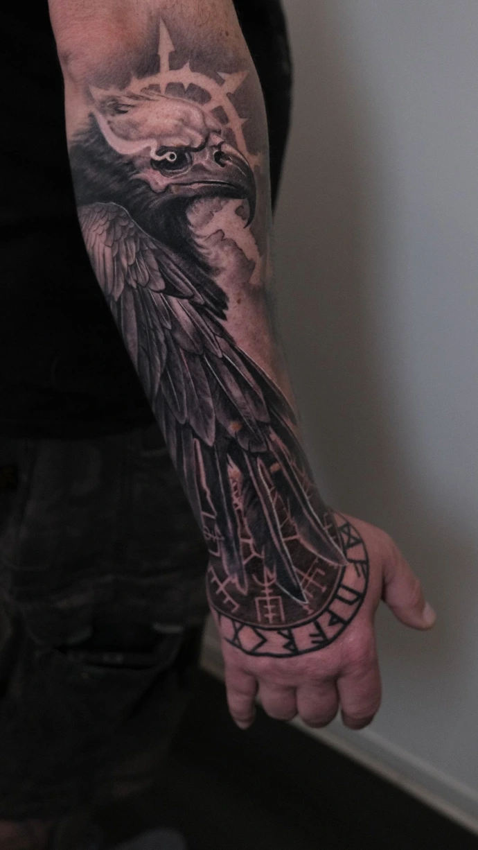 Dein realistisches Raben-Tattoo mit mystischem Symbol in Friedberg, Hanau und Frankfurt am Main – book your professional black and grey forearm session now. Realistic Black and Grey Raven and Mystic Halo Forearm Tattoo in Friedberg Hanau Frankfurt am Main