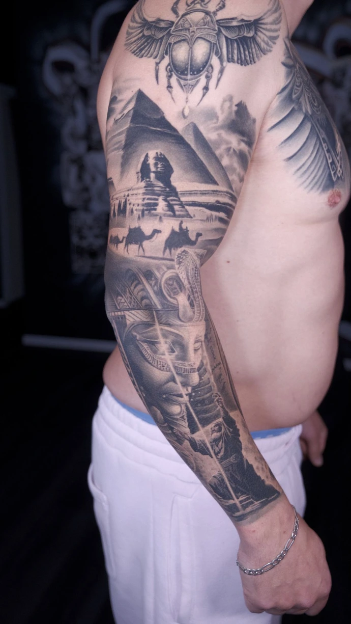 Dein exklusives Ägypten-Realismus Tattoo mit Pharao, Sphinx und Pyramiden in Friedberg, Hanau und Frankfurt am Main – book your professional black and grey sleeve session now. Realistic Black and Grey Egyptian Sleeve Tattoo with Pharaoh Sphinx and Pyramids in Friedberg Hanau Frankfurt am Main