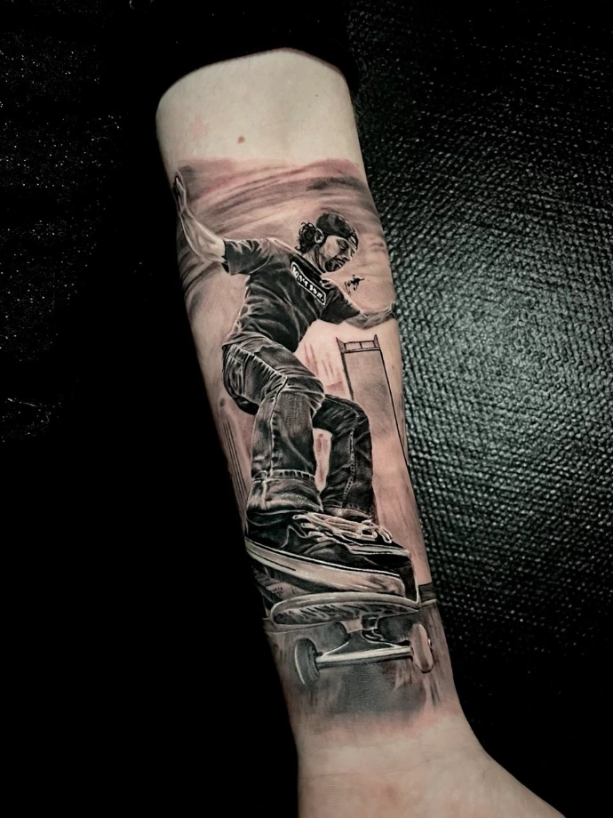 Dynamisches Schwarz-Weiß-Tattoo eines Skateboarders im Realismus-Stil am Unterarm von Experten in Friedberg, Frankfurt am Main und Hanau.